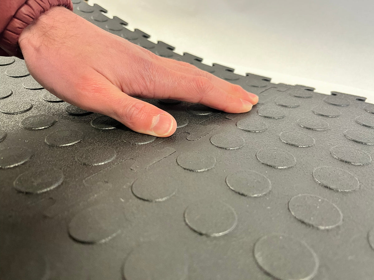 Hand pressing interlocking garage floor tiles together